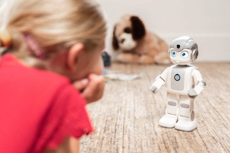 Meisje kijkt naar kleine robot